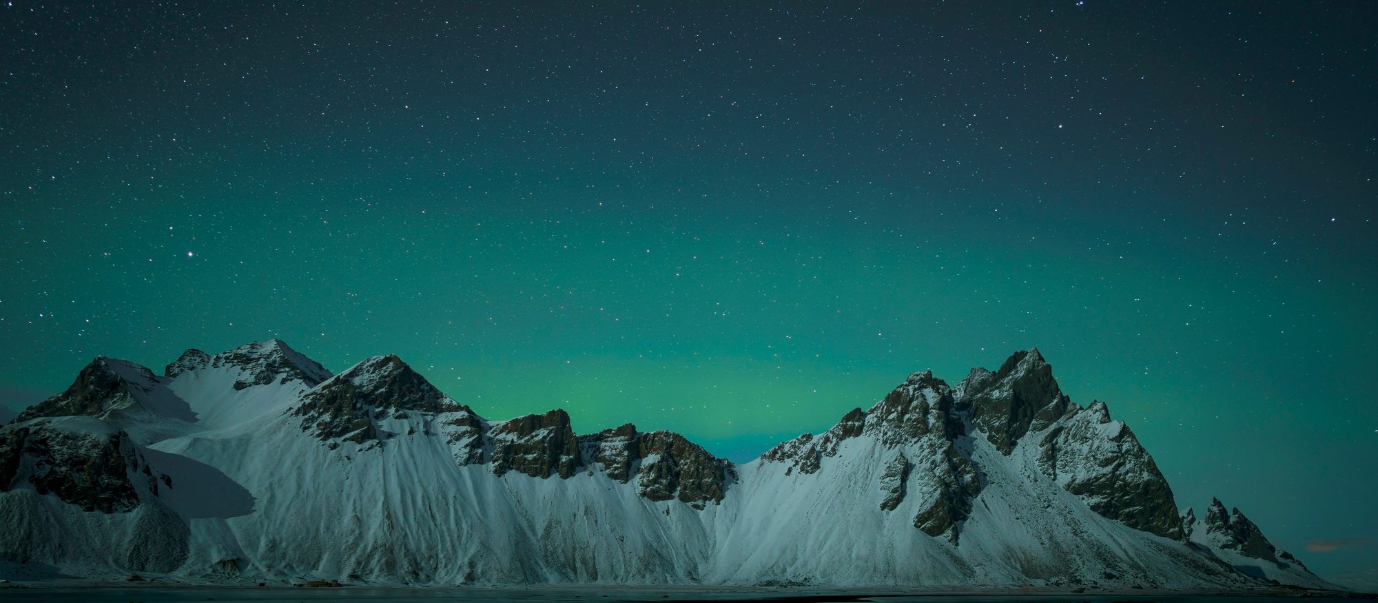 Snow covered peaks beneath the northern lights